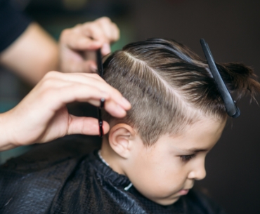 Chłopiec na fotelu w salonie fryzjerskim 